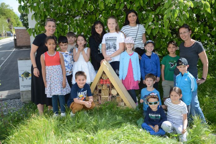 Die Kinder der Mehrstufenklasse B der Volksschule zwei mit ihren Lehrerinnen beim Aufstellen des neuen Insektenhotels im Wörgler Freigarten Die Kinder der Mehrstufenklasse B der Volksschule zwei mit ihren Lehrerinnen beim Aufstellen des neuen Insektenhotels im Wörgler Freigarten